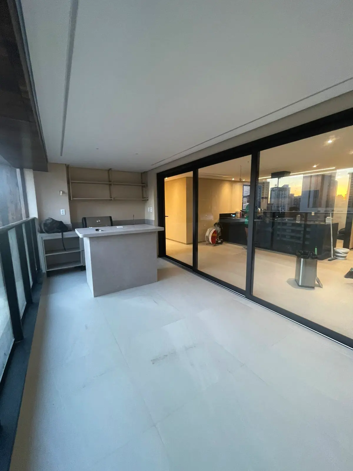 Porta de correr em PVC escuro integrando varanda e sala